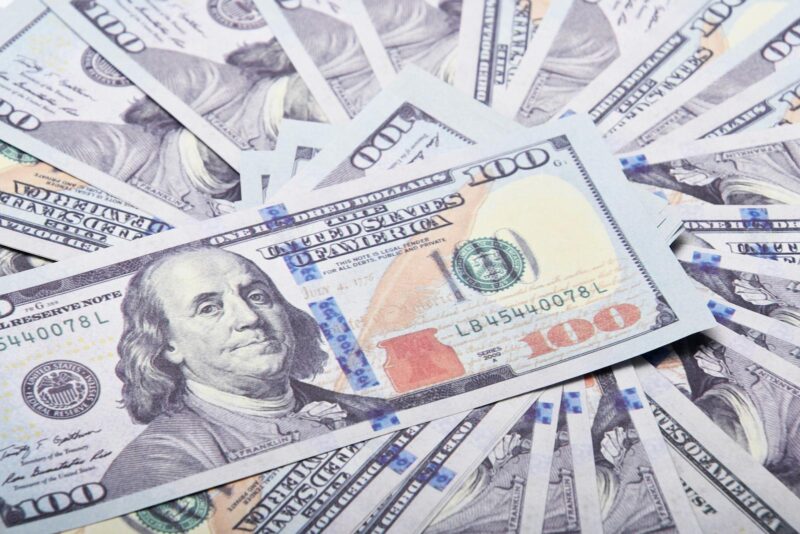 A stack of hundred dollar bills spread out, symbolizing wealth and financial success.